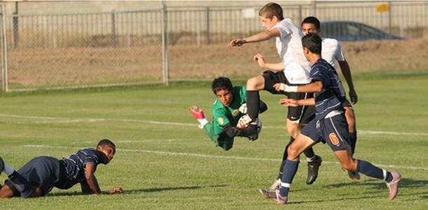 Freshman Goalkeeper Leonel Luna charges the ball to prevent several Lassen College players from scoring a goal in the first half. The Hawks lost the game 2-1 on Oct. 26.