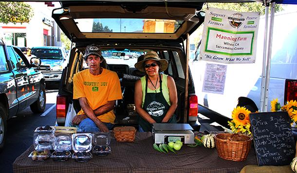 Spivia (right) and Yvonne (left) Manning sit in the shade and sell their produce at the Elk Grove Farmers Market on Aug. 31.