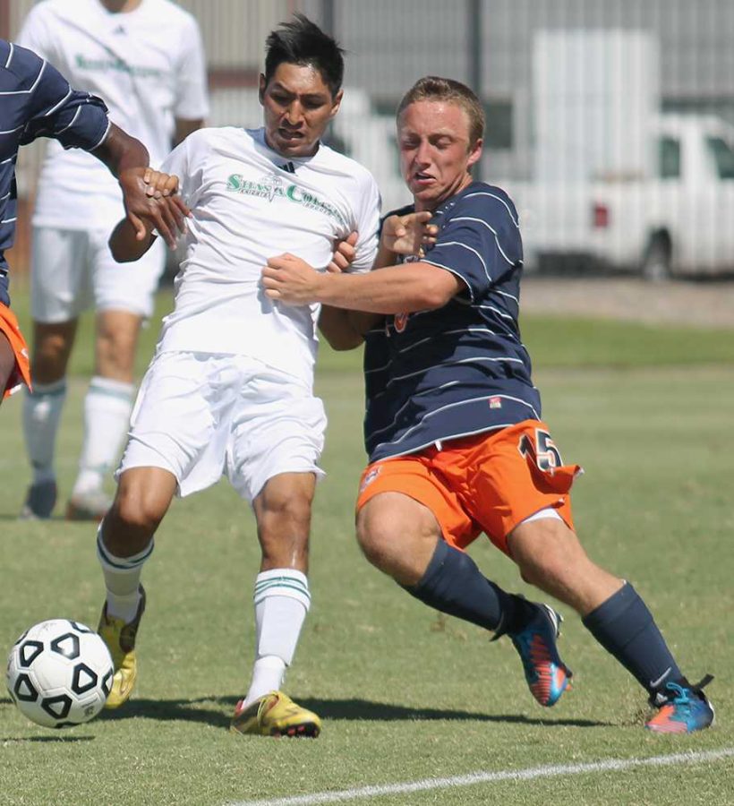 A Shasta College player keeps the ball away from Hawks freshman forward Alexander Herman during their game on Sept. 6. Cosumnes River College hosted the game as a part of the first annual Nor-Cal Colleges Showcase Weekend.