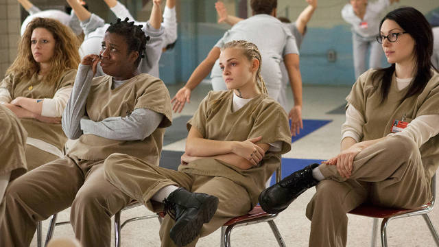 Nicky Nichols, Suzanne Crazy Eyes Warren, Tricia Milner and Alex Vause attend an Alcoholics Anonymous meeting while other inmates practice yoga in the background in episode 5 of Orange is the New Black.
