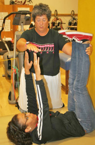 Jeanne Calamar assists Stephanie Solis, an 18-year-old undeclared major, with toe-touch crunches in her adapted physical education class on Sept. 27.