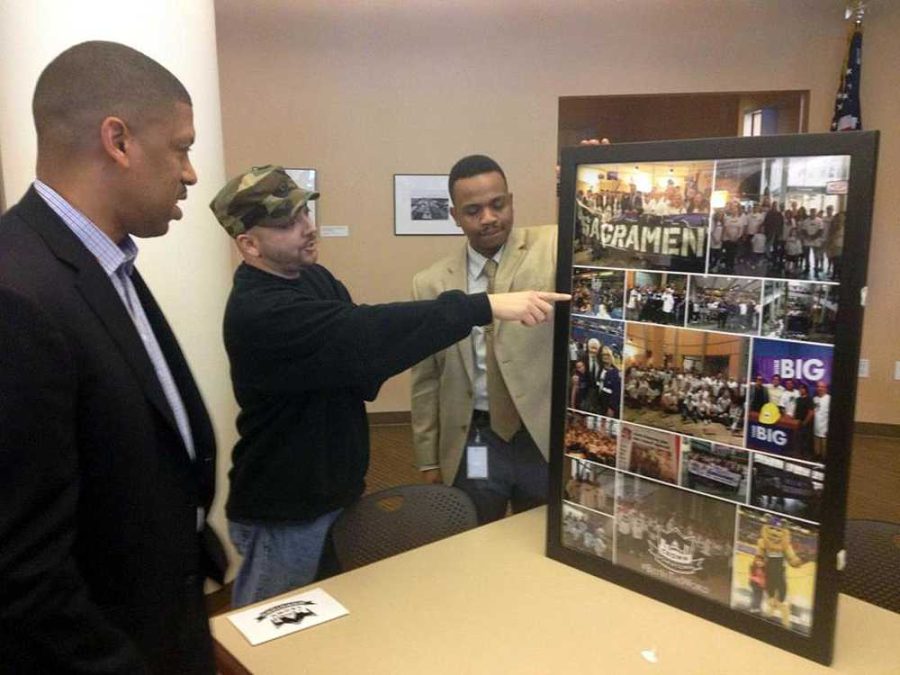 CRC adjunct counselor Mike Tavares presents Sacramento Mayor Kevin Johnson with a gift, a collage of photos, in Sacramento City Hall on Jan. 30.