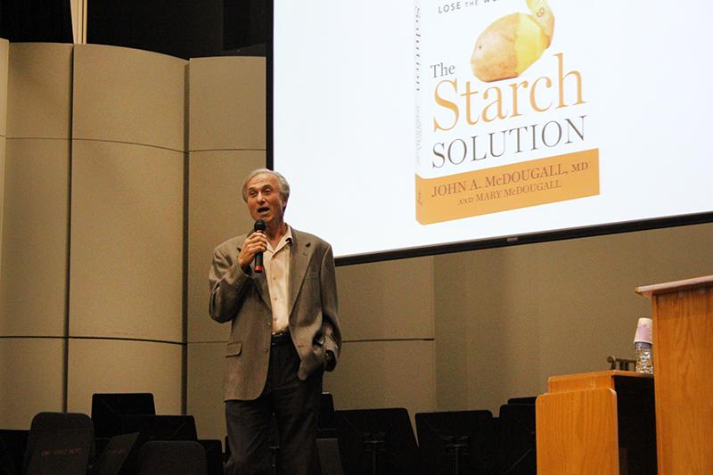 Dr.+John+McDougall+speaks+during+a+One+Book+lecture+about+healthy+eating+habits+in+the+Recital+Hall+on+Oct.+23.+Copies+of+McDougalls+book+The+Starch+Solution+was+sold+at+the+event.+