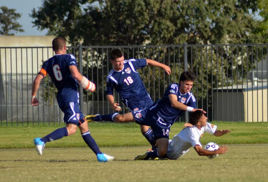 Freshman defender Jose Torres, one of the few starters to play in the game, stumbles over a Taft College soccer player during the first half of the game on Oct. 11 at Cosumnes River College.