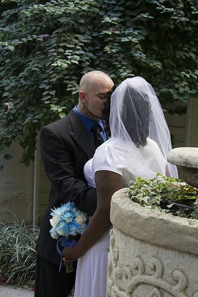 Chad Gianotti Sr. and Cassandra Hamm share a first kiss after the wedding ceremony provided for them, as photographers capture the shot on Nov. 16.