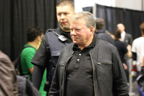 With security close by, William Shatner of "Star Trek" fame walks the aisles of the Convention Center on the way to his booth.