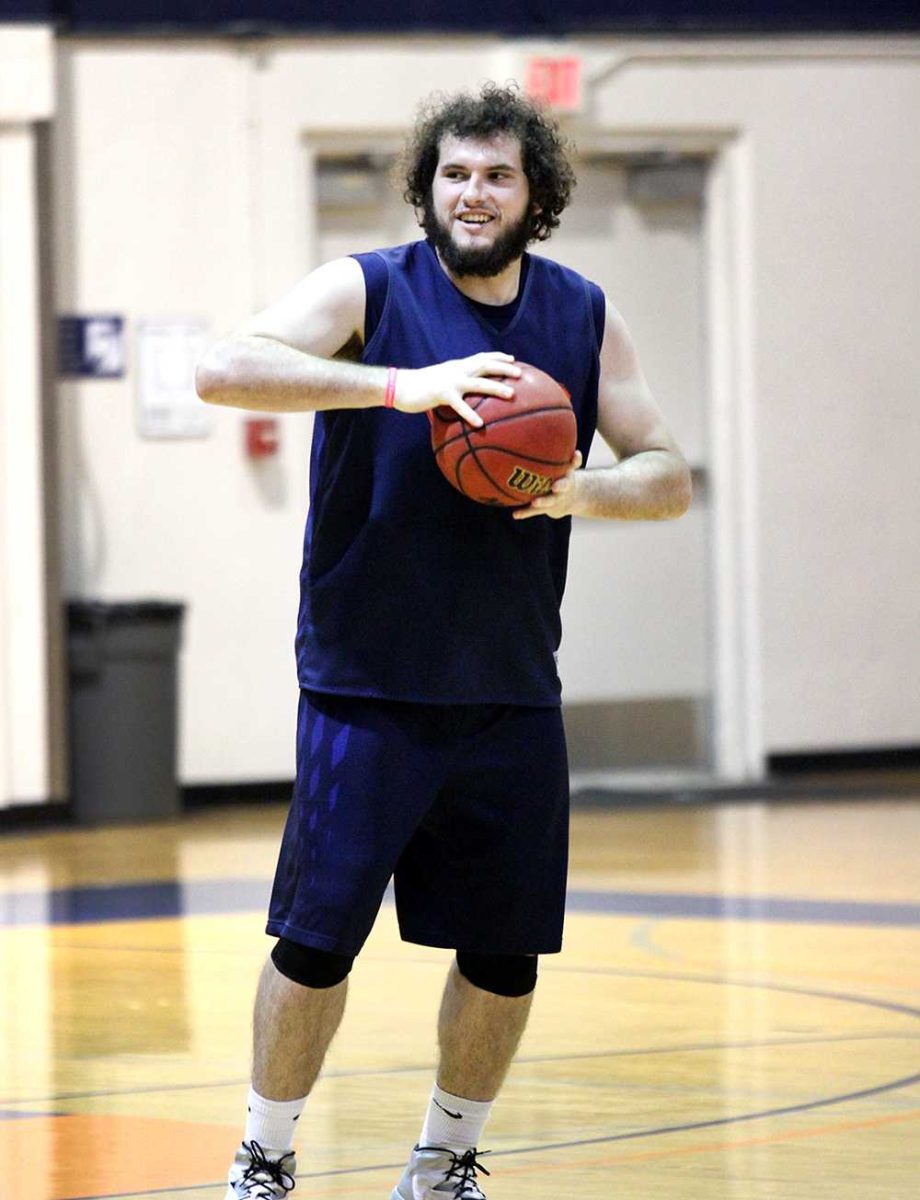 Sophomore forward Jaycob Velasco smiles as he grips a basketball at team practice on March 3. The Hawks are preparing for a quarterfinal matchup with Fresno City.