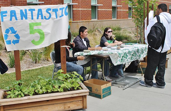 Fantastic Five members Kathryn Villagrana, Ramiro Madrigal and Bethany Mulligan work a table during the campus Earth Day event outside the Winn Center, to explain their project and collect food to donate to Food Not Bombs on April 24. 