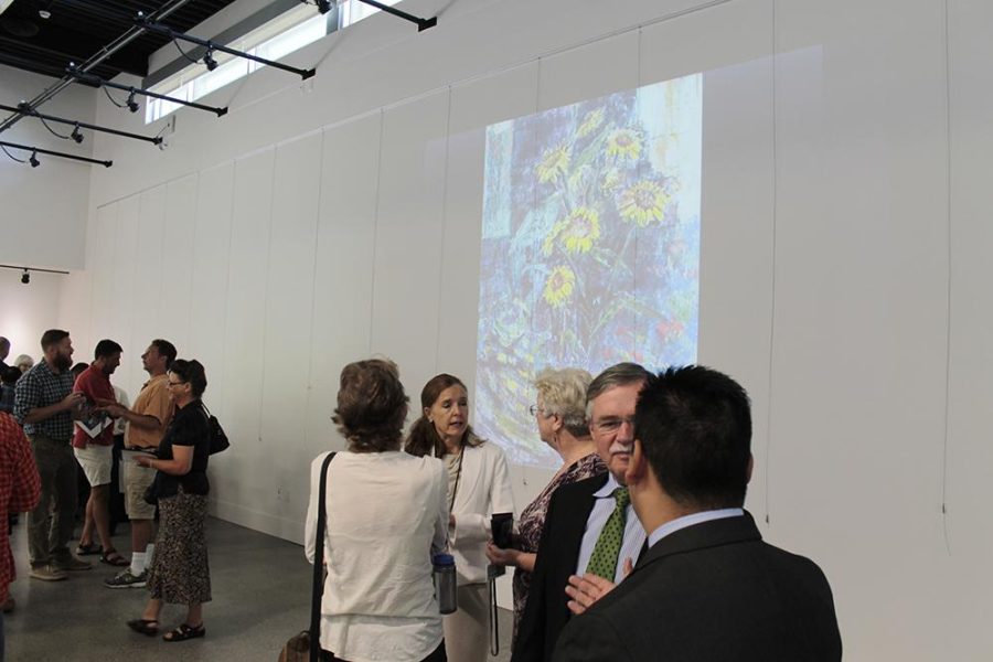 Members of CRC faculty, administration and guests tour the art gallery after its dedication. While there is no art on the walls just yet, a slideshow is projected on the wall showcasing art from campus and the community that will decorate the walls in the future.