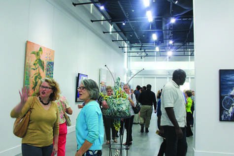 Photography Professor Kathryn Mayo (left) and Art Professor Margaret Woodcock (right) socialize while walking through the gallery looking at the various pieces of art displayed in the exhibition.