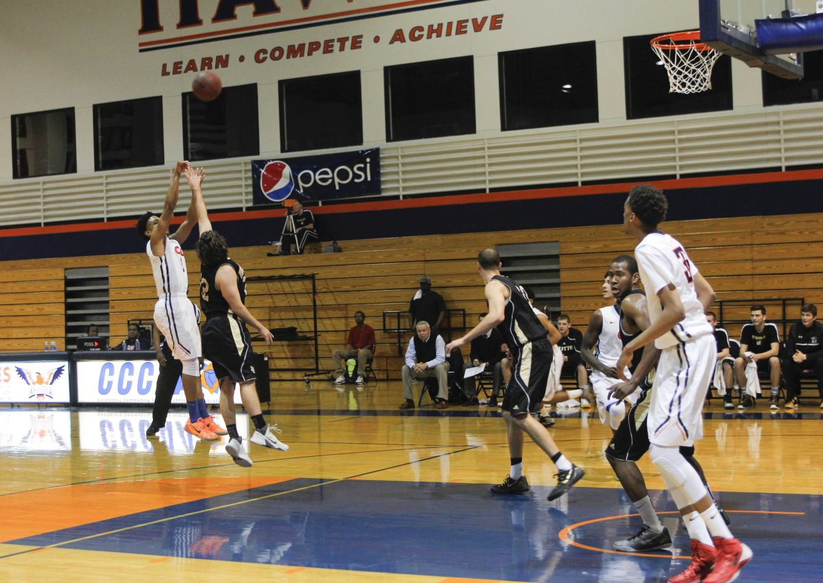 Sophomore guard for the Hawks Mitchell Love trying to make a shot over the Roadrunners sophomore forward Arthur Caldwell.