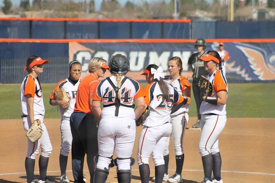 The softball team meeting with Coach Kristy Schroeder on the mound to talk during one of their double header games against Butte College on Feb. 27.