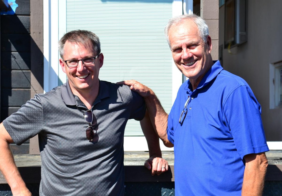 Professor Jason Ellis and father John Ellis meet with students in the construction area to work on the tiny house project.