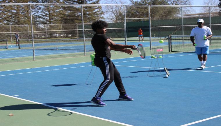 Freshman player Paradise Whalen works on her forehand with Assistant Coach Edmund Carter during practice.