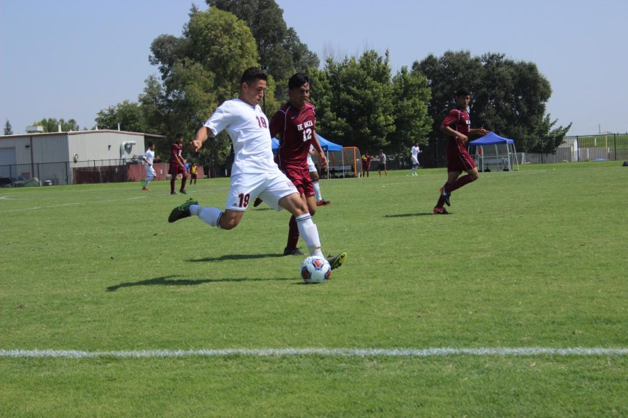 Freshman+midfielder+Ivan+Gutierrez+drives+the+ball+at+the+end+of+the+Hawks+game+against+De+Anza+on+Sept.+8.