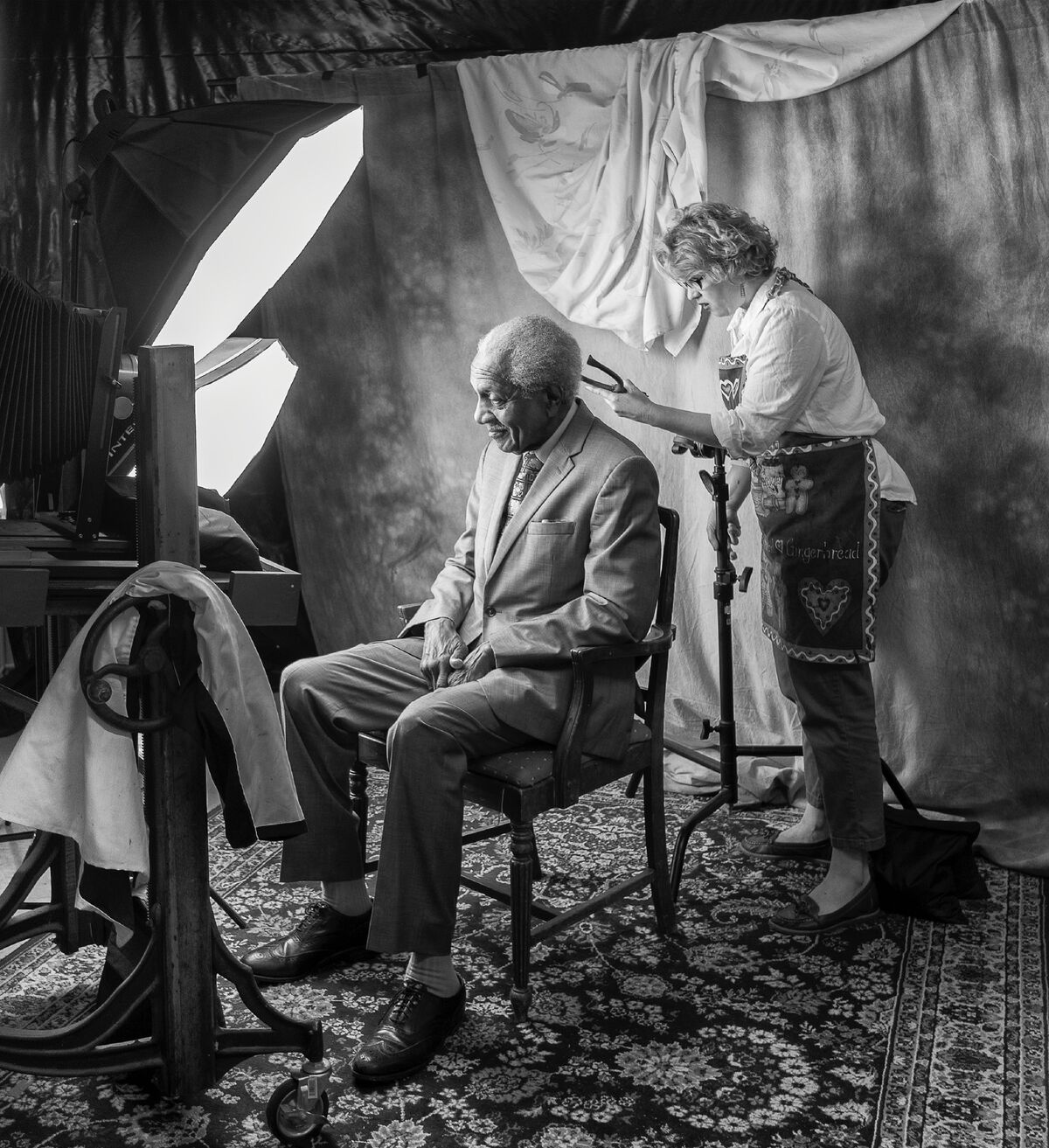 In a photo taken by her husband, who served as an assistant during the project, Professor Kathryn Mayo preps one of her subjects, F.D. Reese, before taking his photo as part of her sabbatical portrait project