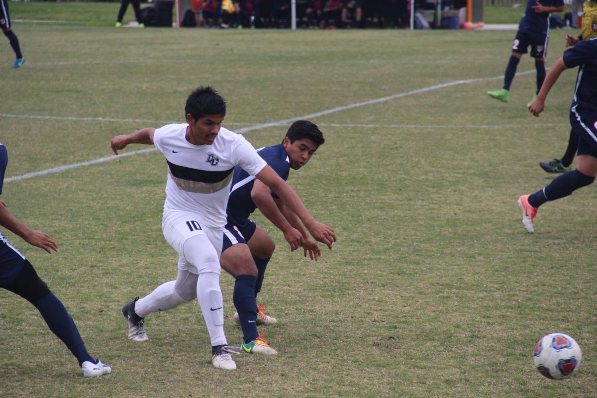 Freshman Midfielder Ivan Gutierrez blocks Delta from a potential scoring drive in the first half. The Hawks defense prevents the Mustangs from scoring a goal, resulting in a 0-0 first half.