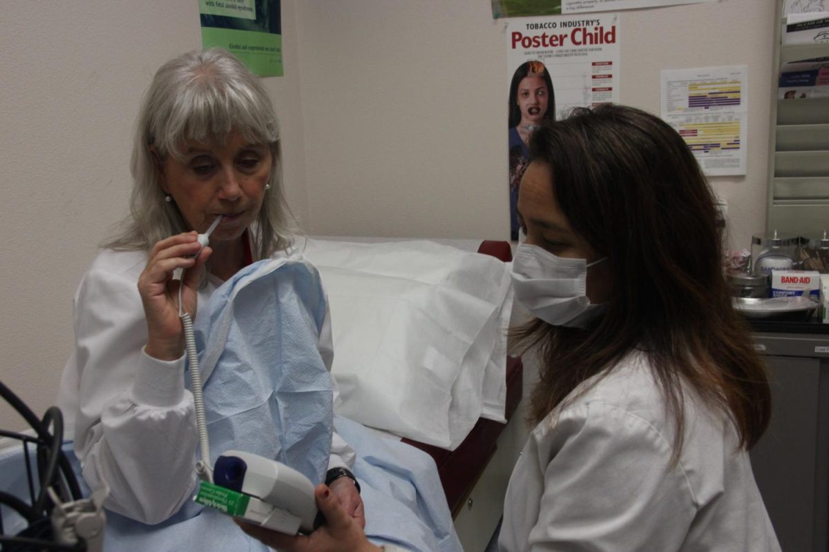 Cosumnes River College Nurse Michelle Barkley, right, takes the temperature of Julie Blaney, adjunct college nurse, on Friday in the health services office. 