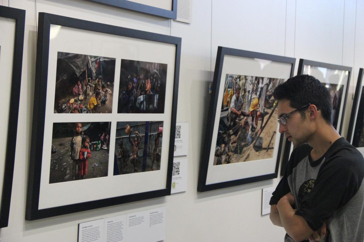 Austin Gonzales browses the photo collection by Renne C. Byer, showcasing poverty around the world.