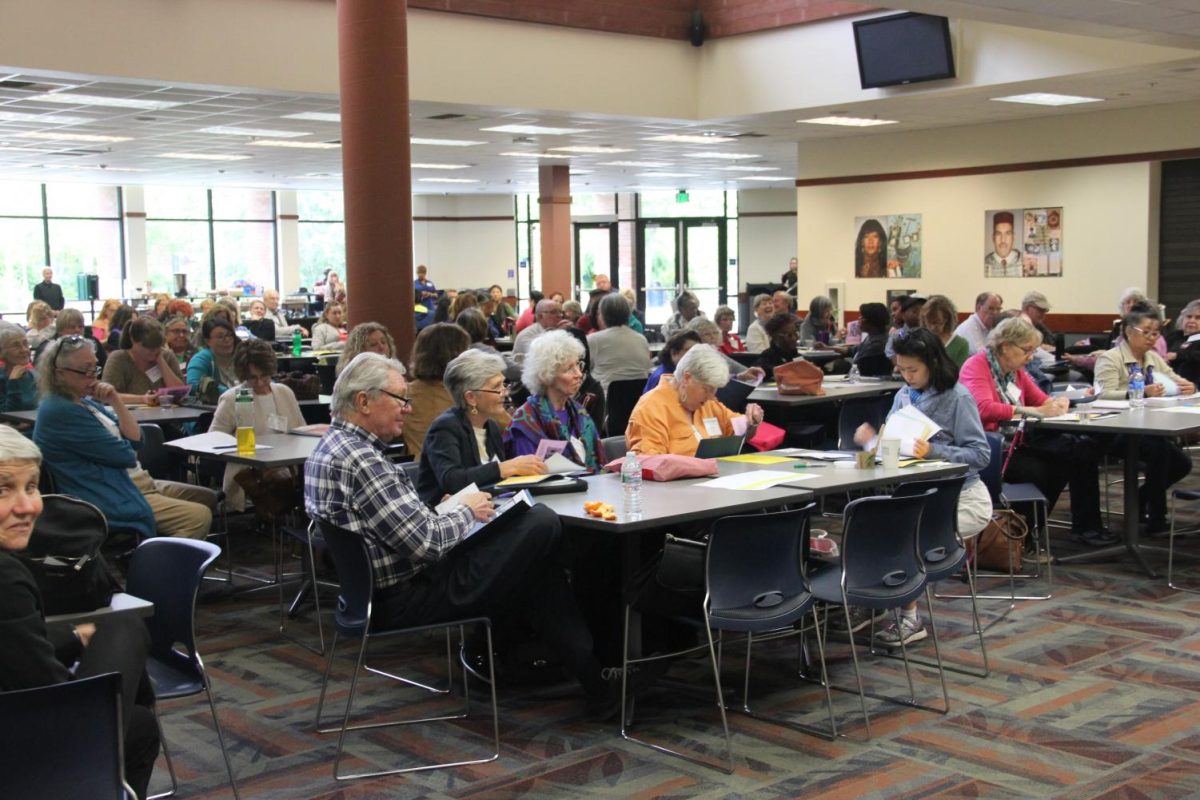 Student, senior citizens and volunteers work on their exercises and assignments in the cafeteria on April 28.