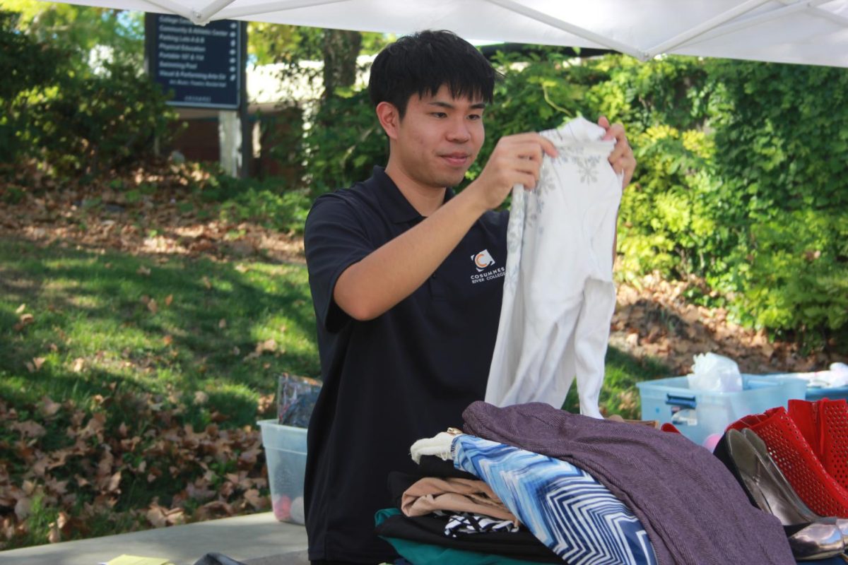 Jonathan Leong sorts through clothes for "Hawk Swap." Leong, who is a business administration major, spends time outside of class to help on campus.