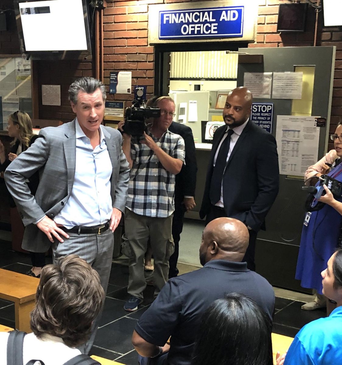 Gov. Newsom talks to a group of students and faculty near Financial Aid office.