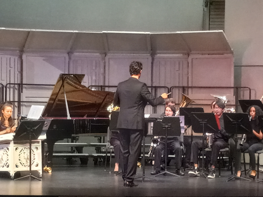 Music professor Maxwell Kiesner conducting the band and orchestra.