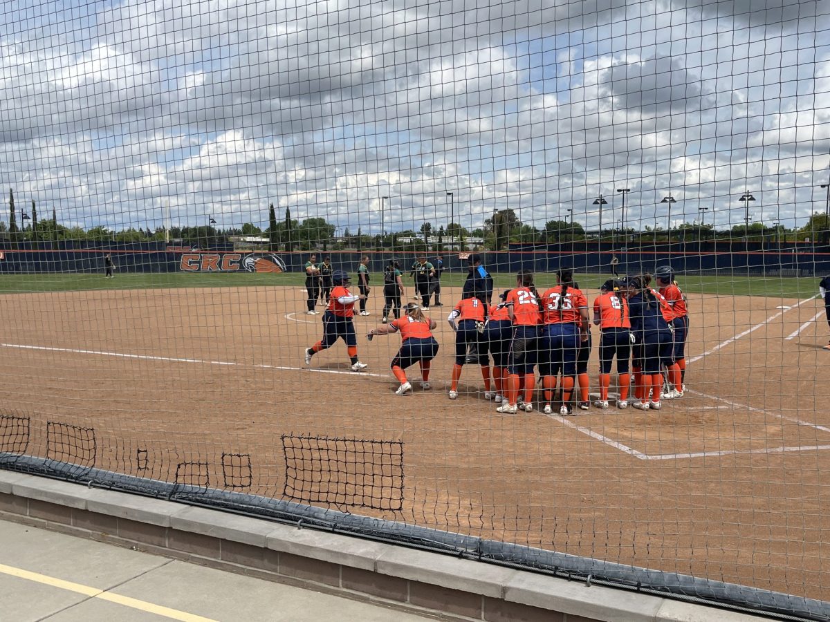 Freshman third baseman Layla Towner teammates greet her after she hit a home run. The softball team beat FRC on Saturday in the first round of the playoffs with a final score of 8-0.