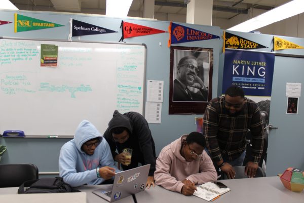 Umoja Diop Student Personnel Assistant Malik Amos (far right) and three students study in the Umoja center. The center is located at L-215 on the first floor of the library and provides community to African American and other students.