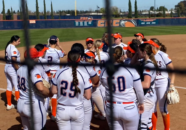 The Hawks softball team huddles during the 5th inning, preparing for game two of their double-header against the Folsom Lake College Falcons on March 8. The Hawks won both games against the Falcons 8-0 and 11-2, finishing early by way of the mercy rule.