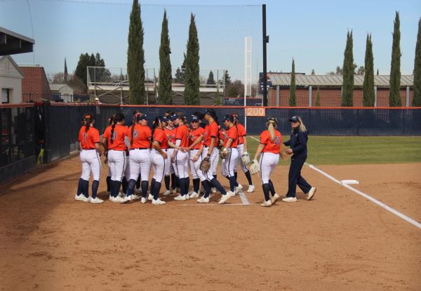 Softball head coach Kristy Schroeder joins the team in a huddle after the Hawks faced San Jose City College on Feb. 11. The team improved to a 19-15 overall record after defeating Sierra College 11-0 on April 12.