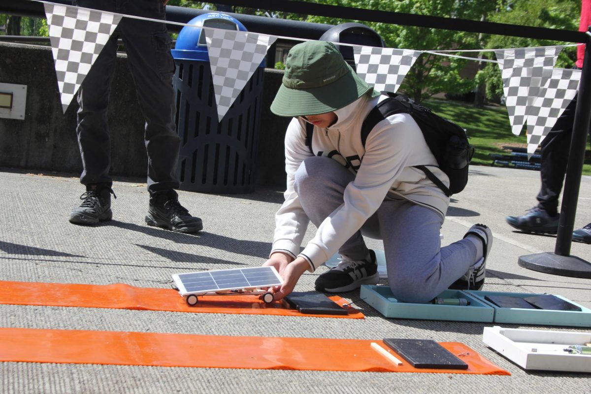 A middle school student stops a solar car at the end of the track. SMUD hosts the solar car race every year at Cosumnes River College for middle and high school students.
