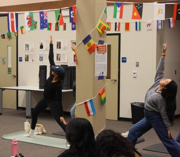 Wellness Advocate Akaysia Hill helps guide a yoga class with positive affirmations in Library L - 106 as part of Women's History Month. Hill created the event to bring peace of mind to attendees, she said.