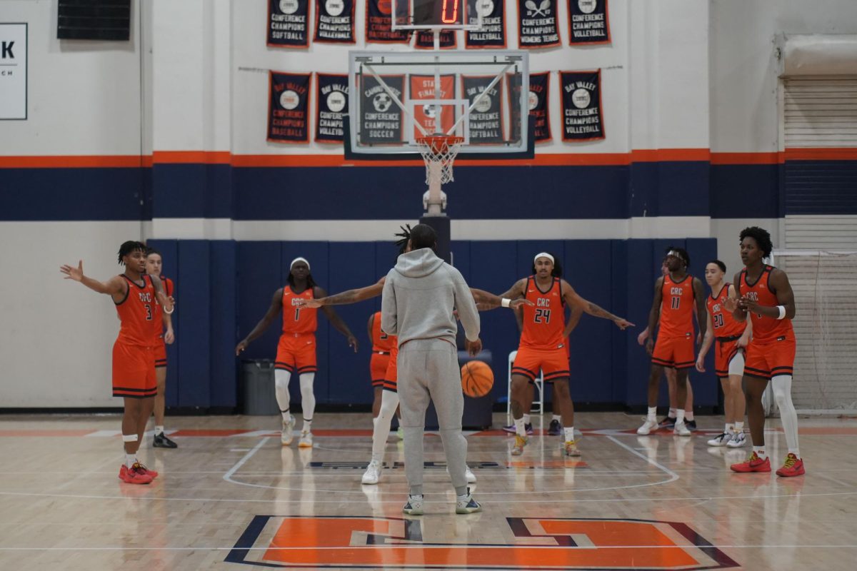 Men's basketball assistant coach Bernard Seals leads the team through warmup drills. The Hawks ended their season with a 21-11 overall record, advancing to the quarter finals of the 3C2A championship before ending their season.