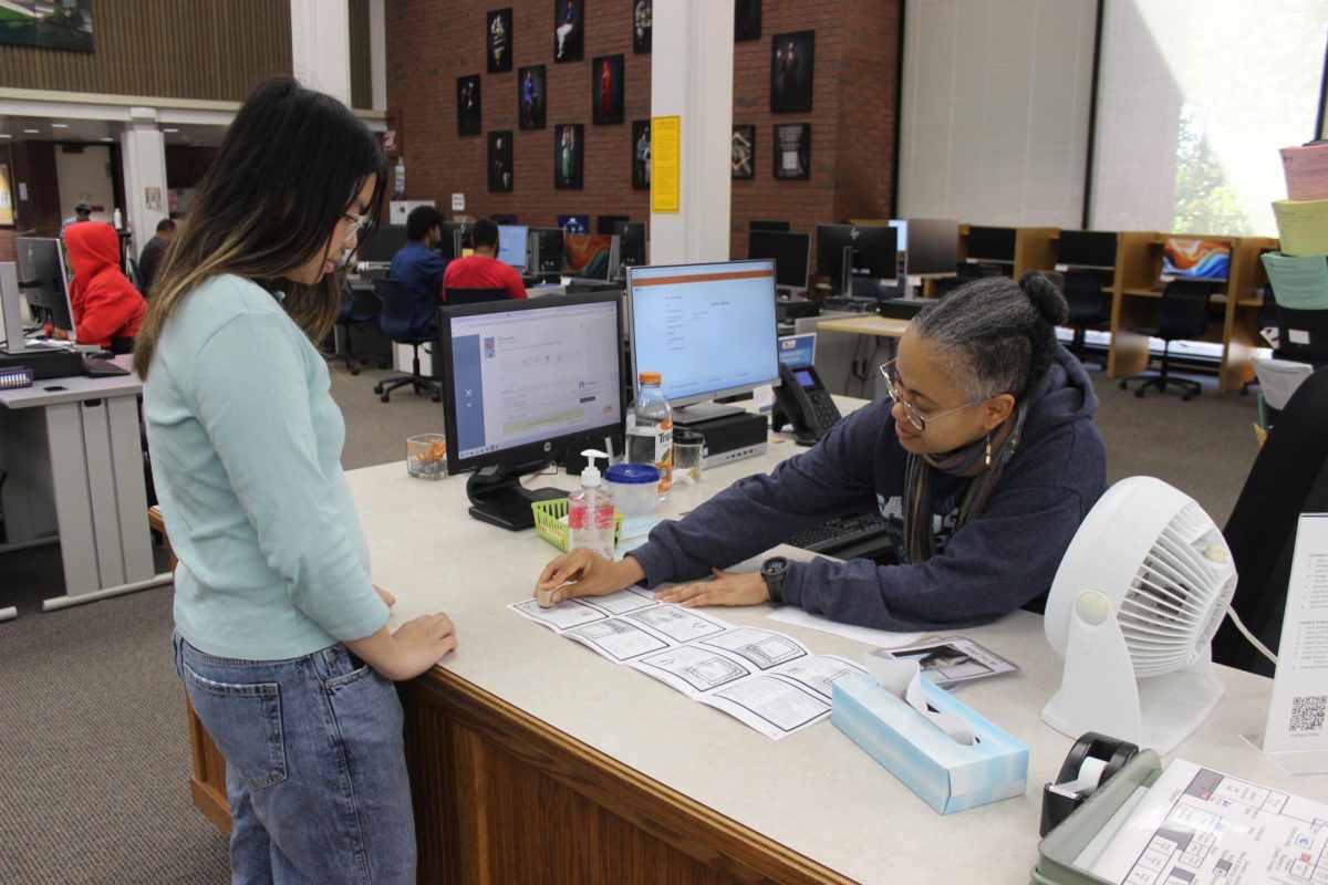 Librarian Viola Allo stamps Melody Jolie Nguyen's passport on Thursday for completing multiple tasks at the library, earning her eight points. As part of the 3-week Passport to Success challenge, students can redeem points for prizes.