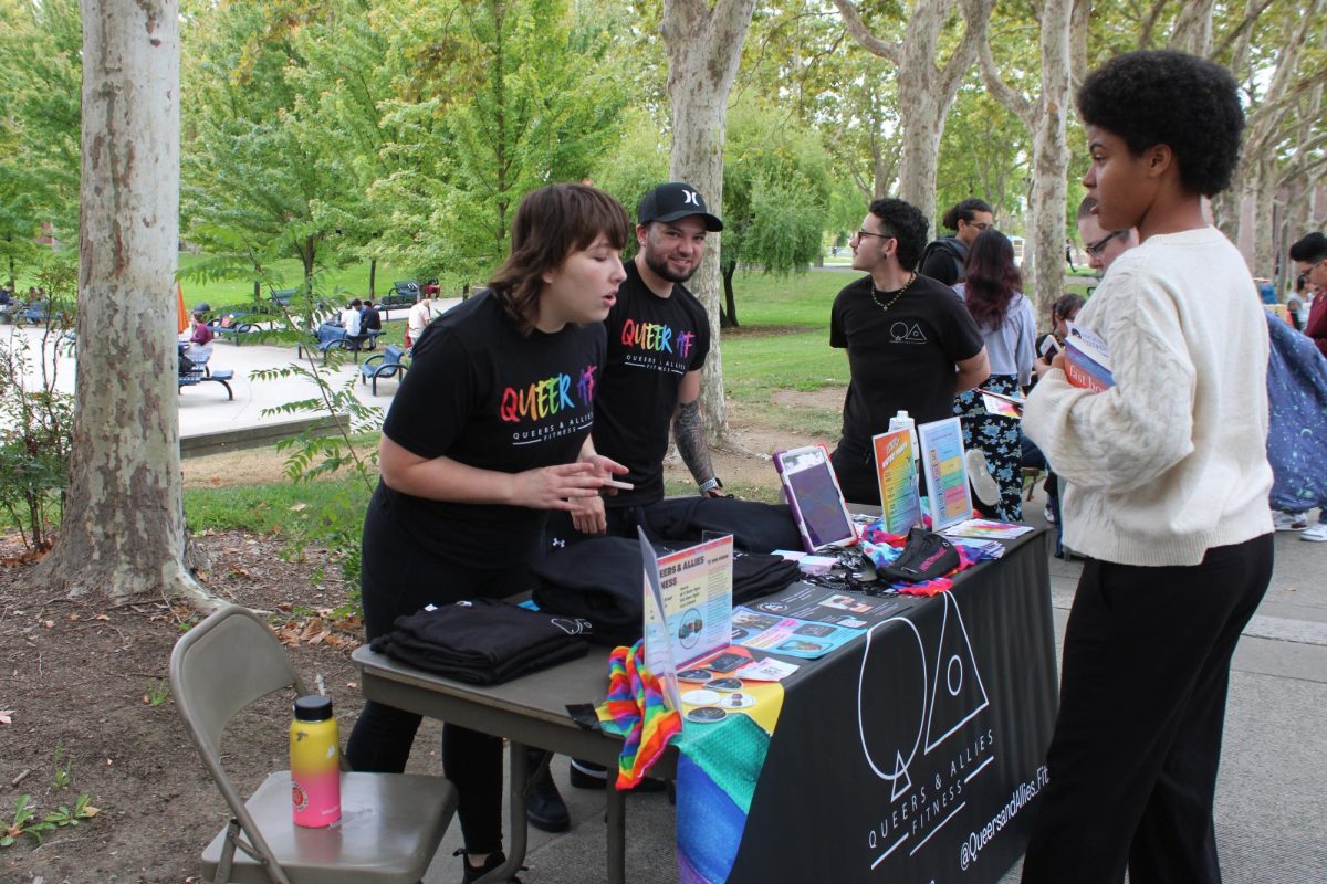 Nikolai Lee, a 20-year-old art major, visits the Queers and Allies Fitness booth at the LGBTQ+ history month kickoff event on Oct 1. The event brought local resources and guest speakers to the campus to support and provide information to the LGBTQ+ community. 
