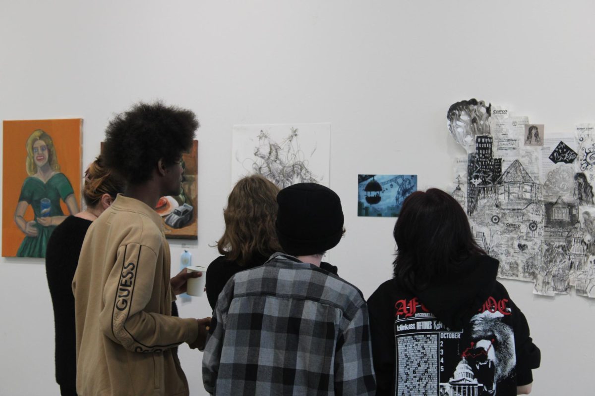 Attendees admire students’ artwork in the Cosumnes River College art gallery during the opening of the “Our Future” exhibit on Nov. 7. The exhibit is available through Nov. 25 by appointment and can be scheduled on the CRC Art Gallery website.