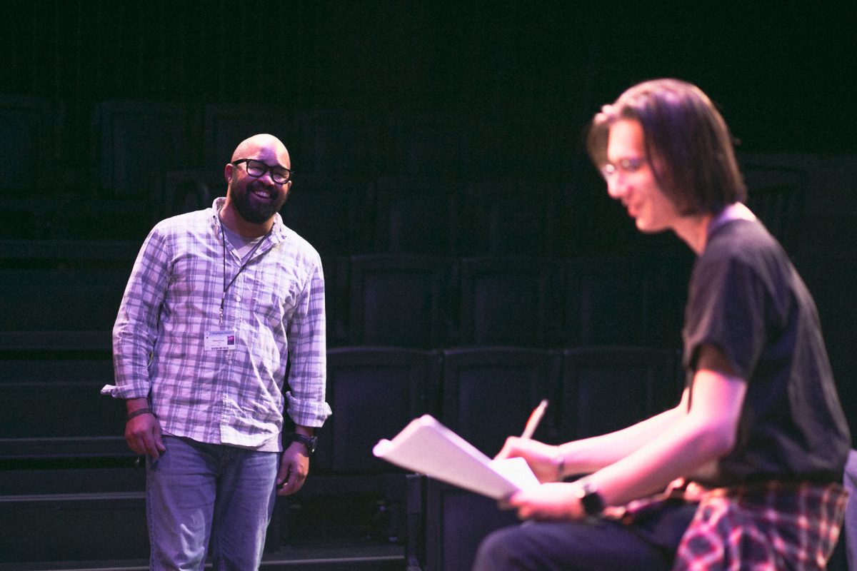 Adjunct Professor Anthony D’Juan laughs with student Michael Vaughn during rehearsals on Dec. 4 in the Black Box Theater in preparation for the student one-act play performances. D’Juan uses his extensive playwriting experiences to challenge his students to tell stories that matter.